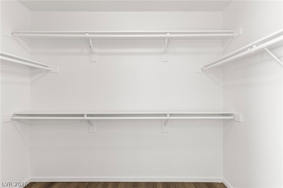 Ample built-in shelving and hanging rods maximize storage space within this walk-in closet.