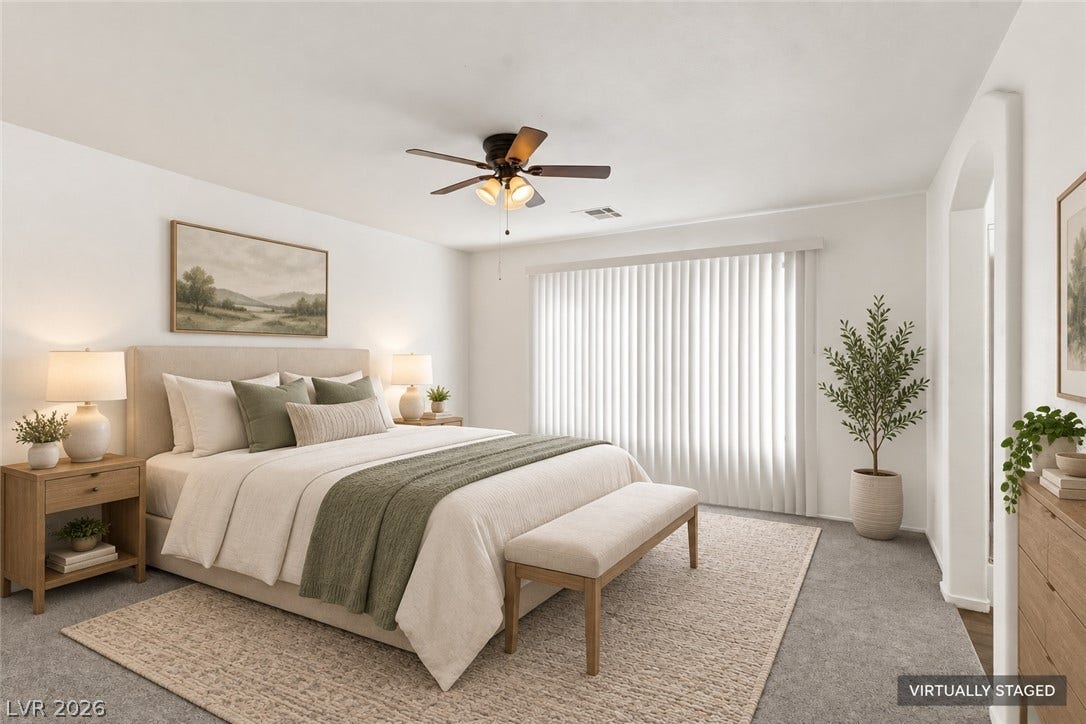 An arched doorway leads into this quiet retreat featuring neutral walls and soft carpet flooring.