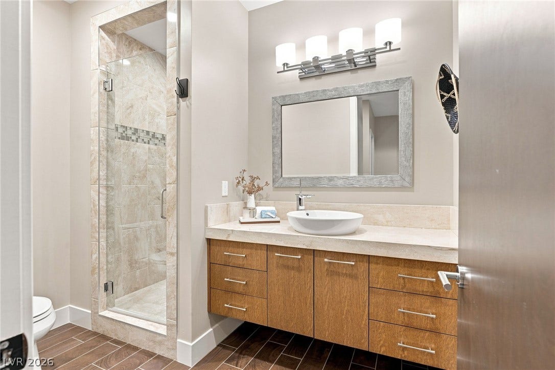 1376 Opal Valley Street, Henderson, NV 89052 A floating vanity and walk-in tiled shower define this contemporary bathroom.