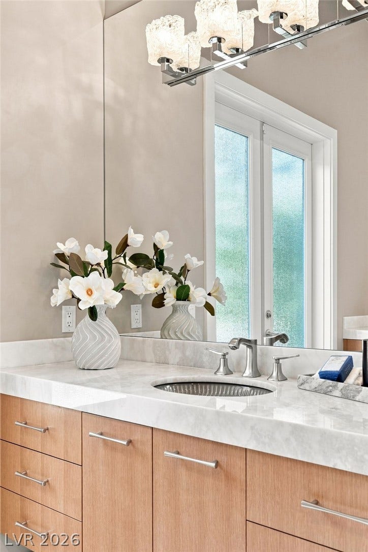 1376 Opal Valley Street, Henderson, NV 89052 A stone counter and custom vanity enrich this elegant modern bathroom space.