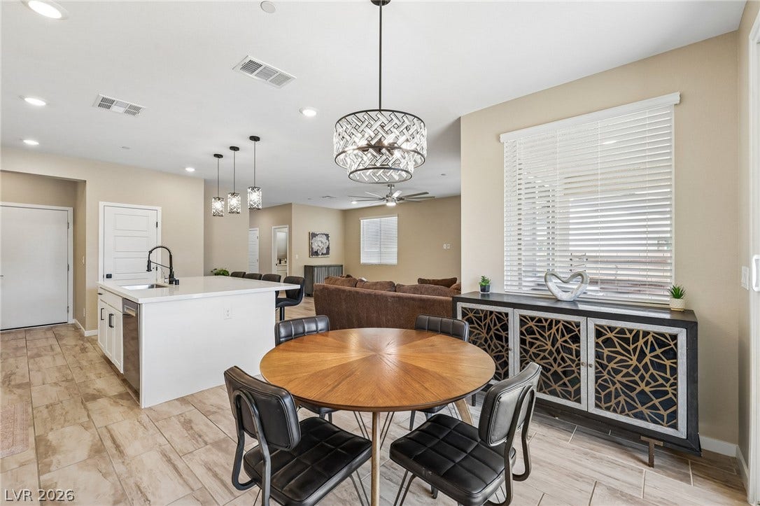 194 Viento Ridge Street, Henderson, NV 89012 Wood-look tile flooring and recessed lighting flow through this open-concept kitchen and dining area.