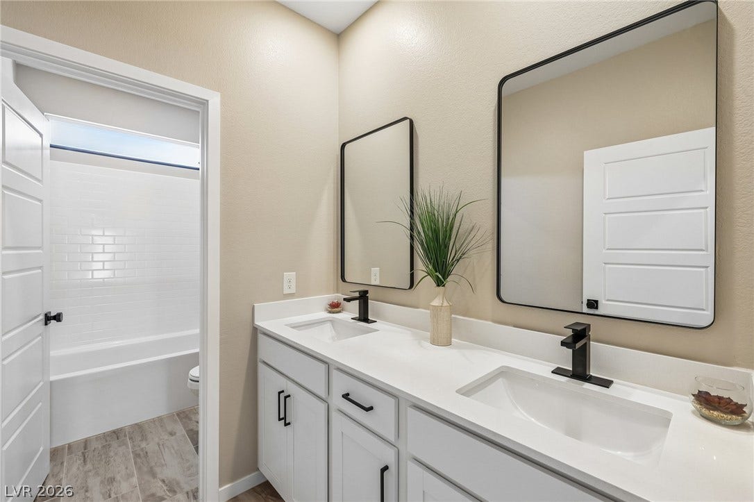 194 Viento Ridge Street, Henderson, NV 89012 A spacious double vanity matches sleek modern fixtures in this refined bathroom layout.