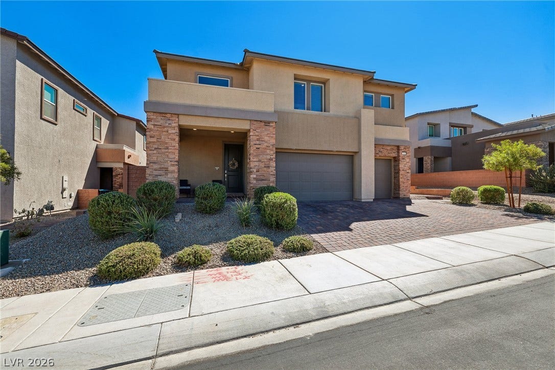 194 Viento Ridge Street, Henderson, NV 89012 A striking modern facade pairs textured stone accents with a spacious paver driveway.