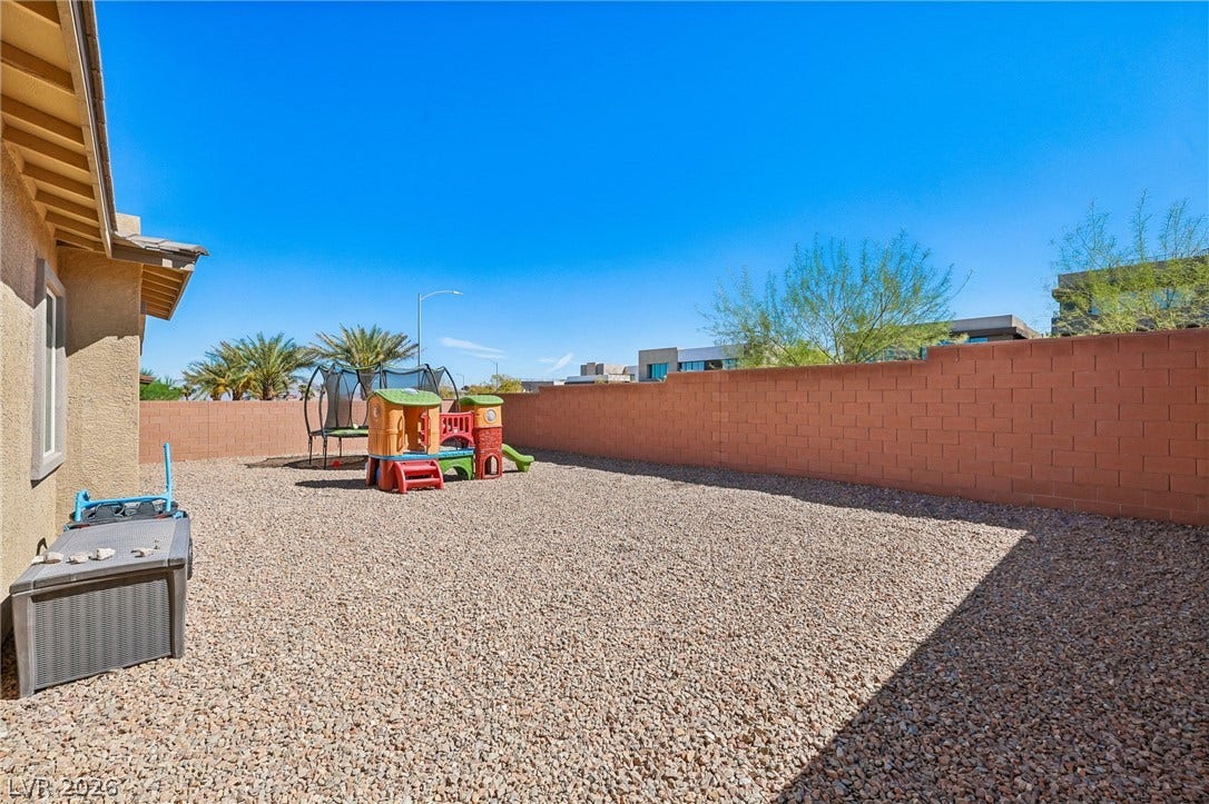 194 Viento Ridge Street, Henderson, NV 89012 A spacious gravel yard is enclosed by a tall block wall under clear blue skies.