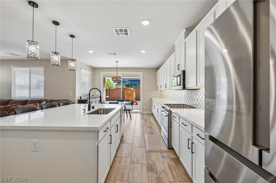 194 Viento Ridge Street, Henderson, NV 89012 An expansive kitchen layout showcases modern white cabinetry and a generous center island.
