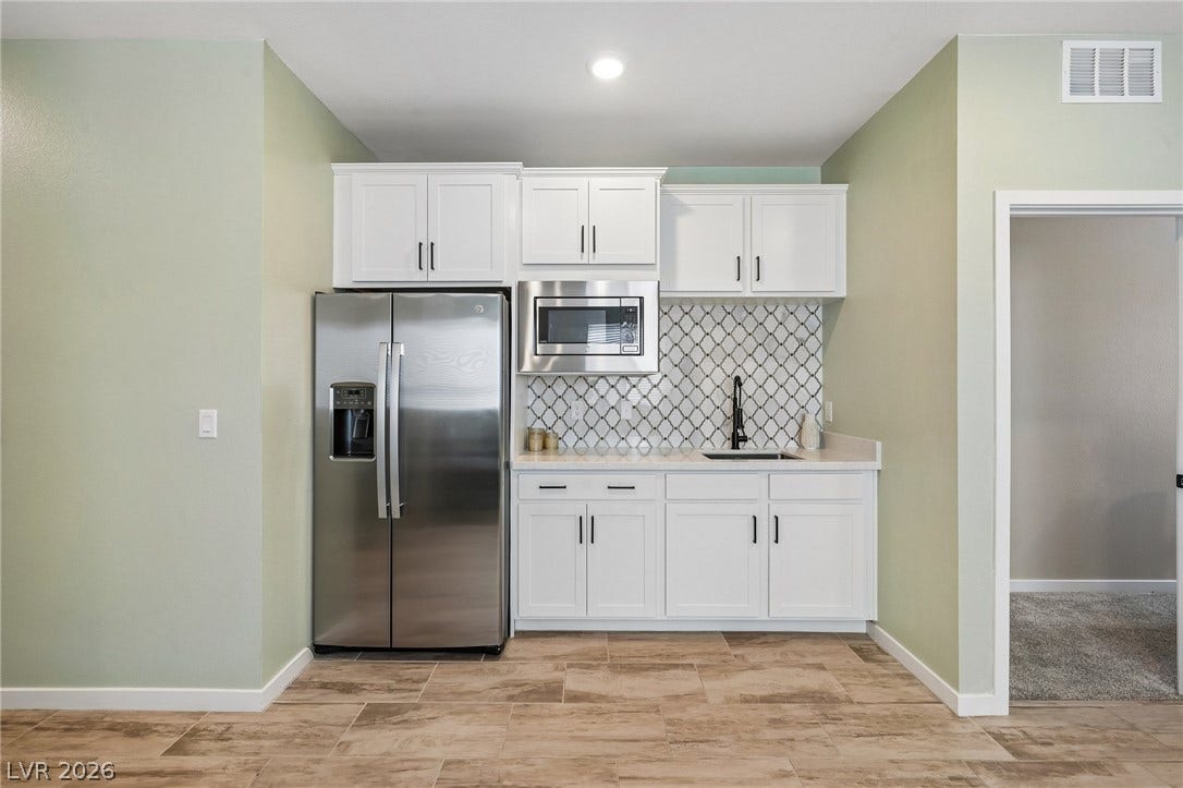 194 Viento Ridge Street, Henderson, NV 89012 Crisp cabinetry and modern finishes create a functional and stylish wet bar area.