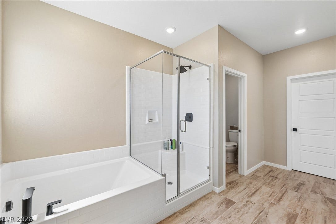 194 Viento Ridge Street, Henderson, NV 89012 Wood-look tile floors complement a glass-enclosed shower and adjacent soaking tub.