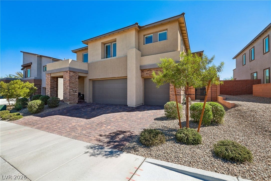 194 Viento Ridge Street, Henderson, NV 89012 An inviting stone-accented facade stands tall beside a beautifully paved driveway and desert landscaping.