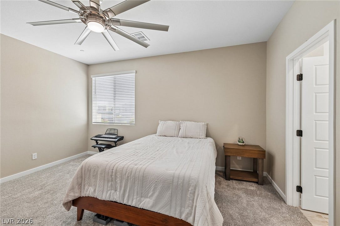194 Viento Ridge Street, Henderson, NV 89012 A windowed secondary bedroom features wall-to-wall carpeting and neutral trim details.