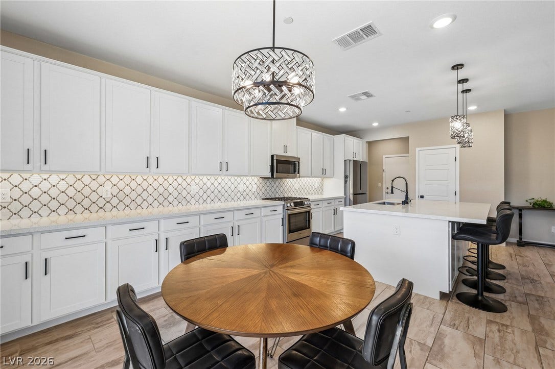 194 Viento Ridge Street, Henderson, NV 89012 Modern cabinetry and recessed lighting anchor this open-concept kitchen and dining area.