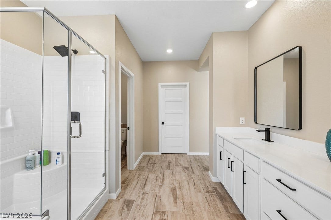 194 Viento Ridge Street, Henderson, NV 89012 Gleaming tile floors and a glass-enclosed shower highlight this modern primary bath.