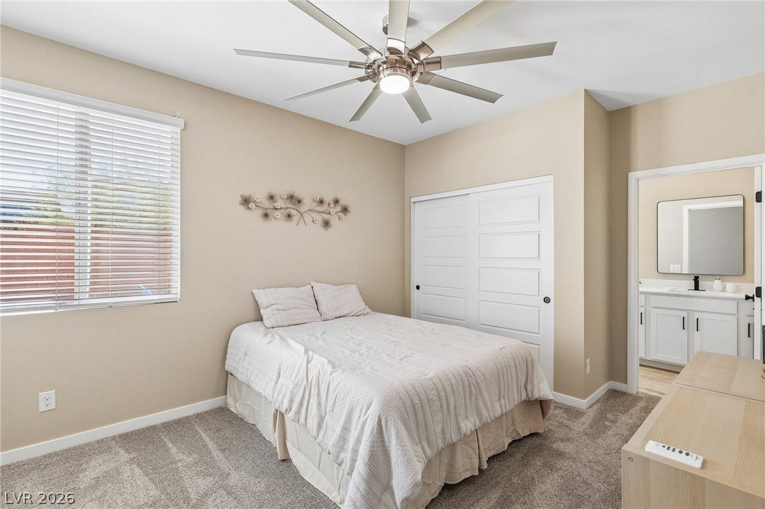 194 Viento Ridge Street, Henderson, NV 89012 Soft carpet and high ceilings define this inviting bedroom space leading to an attached bathroom.