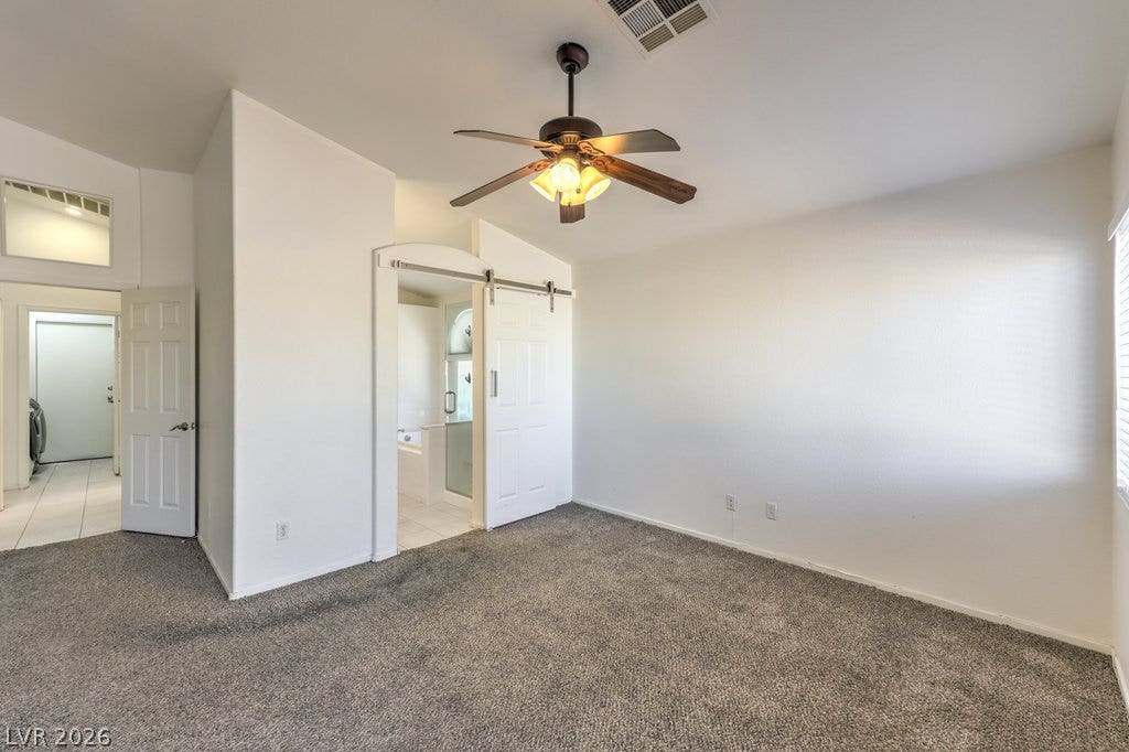 3186 CASTLE CANYON Avenue, Henderson, NV 89052 Vaulted ceilings and plush carpeting define this spacious primary bedroom featuring an attached bath.