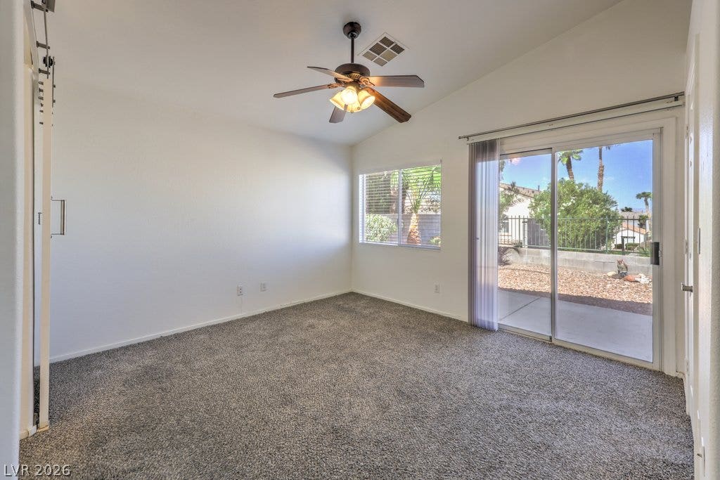 3186 CASTLE CANYON Avenue, Henderson, NV 89052 Sliding glass doors open directly to the patio from this comfortable carpeted room.