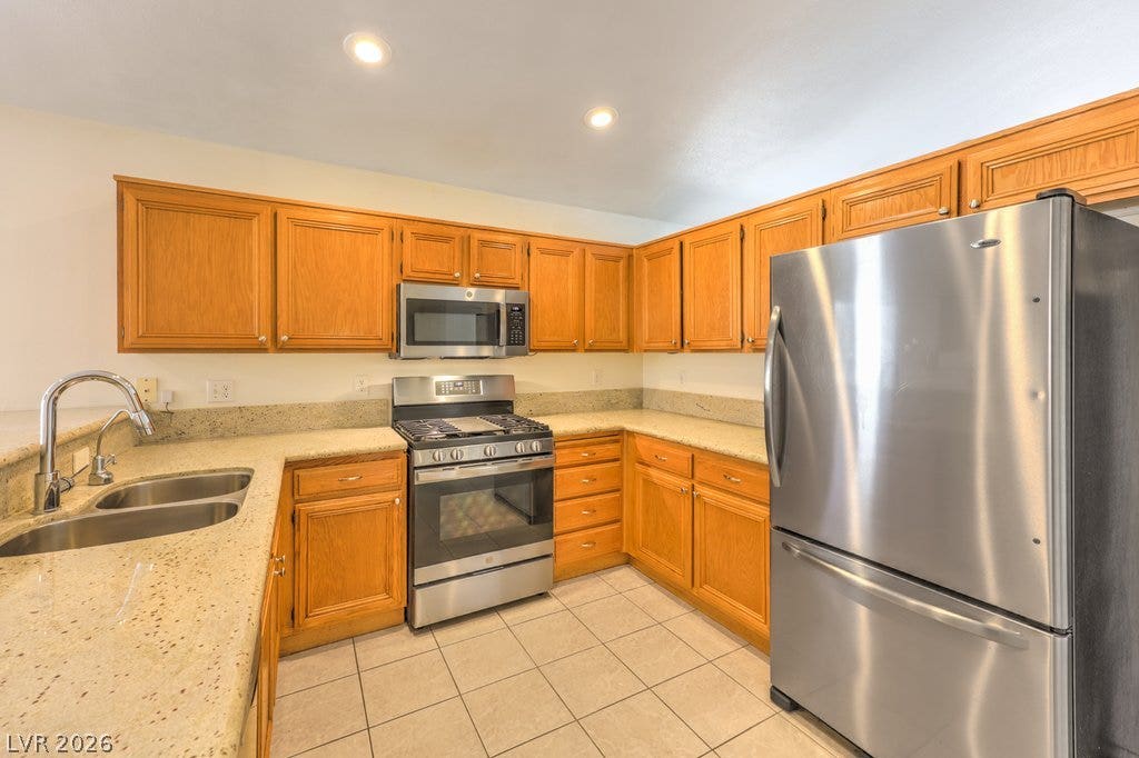 3186 CASTLE CANYON Avenue, Henderson, NV 89052 Warm wood cabinetry meets granite countertops and sleek stainless steel appliances in this functional kitchen.
