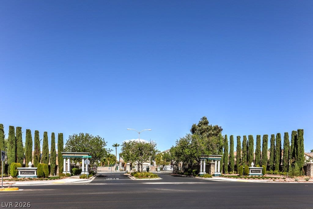 3186 CASTLE CANYON Avenue, Henderson, NV 89052 An inviting gated neighborhood entry features structured stone pillars and mature, manicured landscaping.