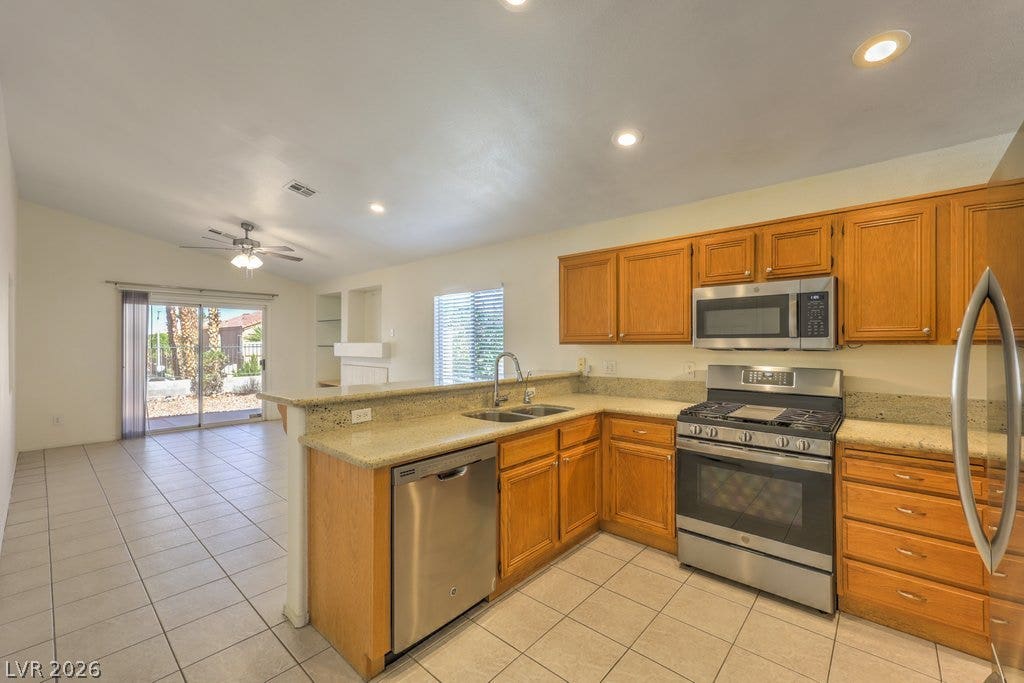 3186 CASTLE CANYON Avenue, Henderson, NV 89052 Gleaming tile floors anchor an airy kitchen opening directly to a relaxed living area.