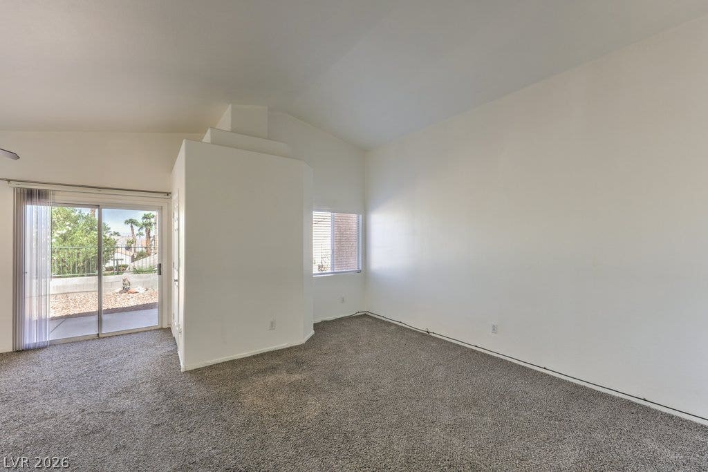 3186 CASTLE CANYON Avenue, Henderson, NV 89052 Sliding glass doors open to a private patio from this vaulted ceiling living space.