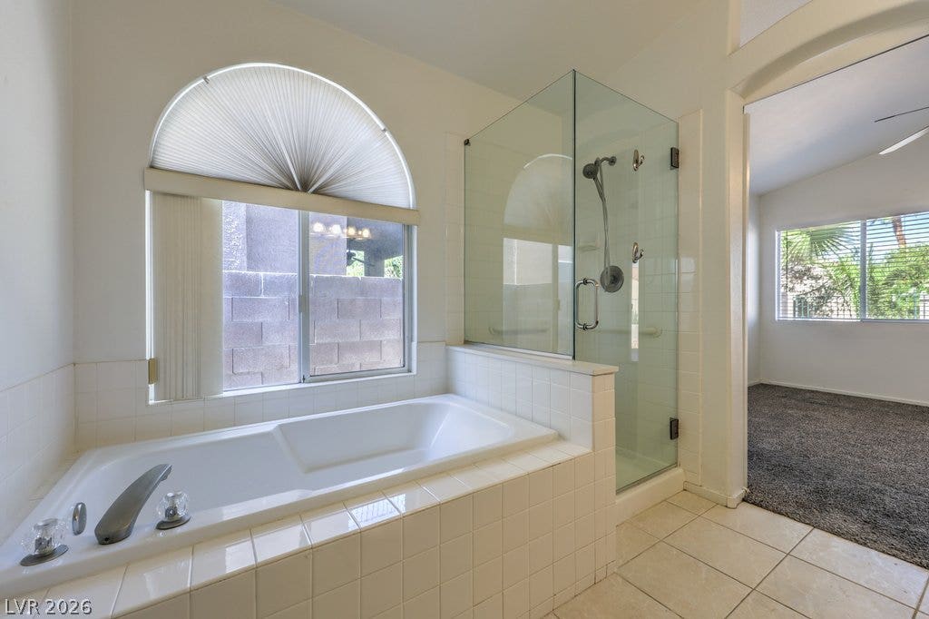 3186 CASTLE CANYON Avenue, Henderson, NV 89052 An arched window bathes this tiled bathroom and deep soaking tub in natural light.