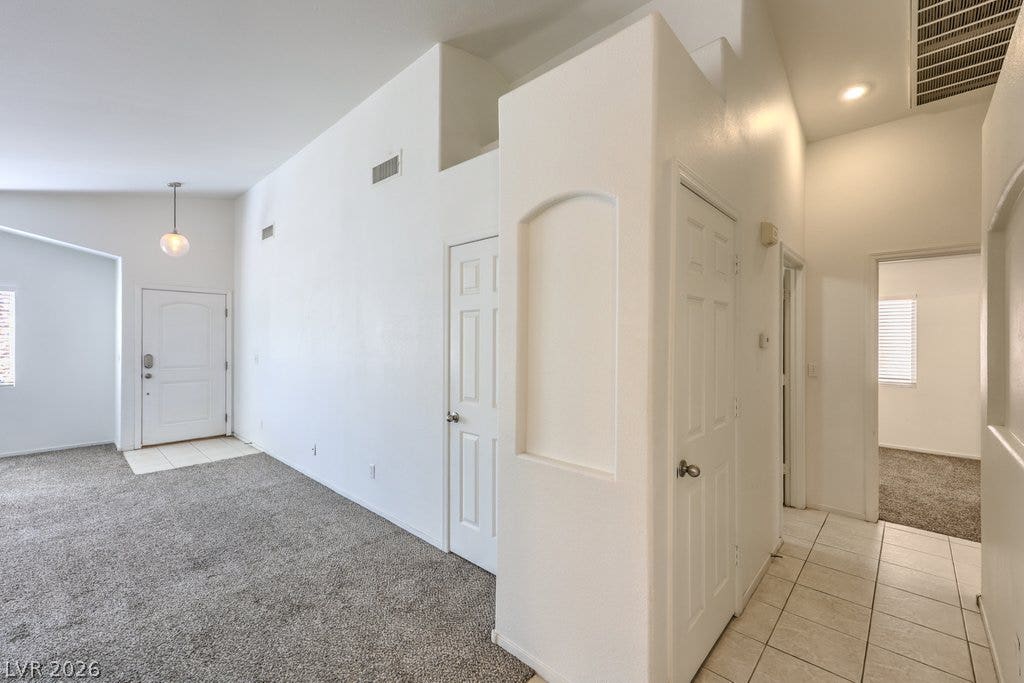 3186 CASTLE CANYON Avenue, Henderson, NV 89052 High ceilings and arched wall niches create architectural depth in this versatile entryway.