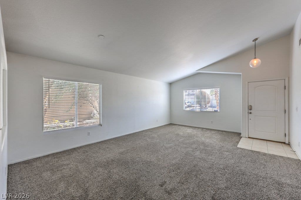 3186 CASTLE CANYON Avenue, Henderson, NV 89052 Vaulted ceilings and plush carpeting anchor this inviting and open living space.