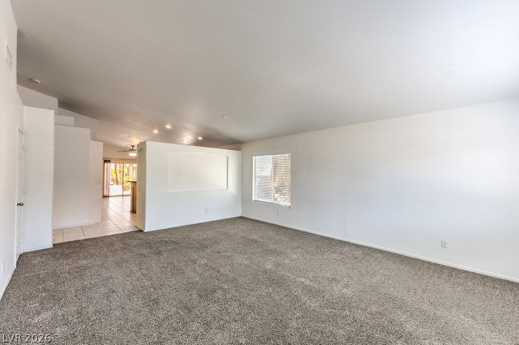 3186 CASTLE CANYON Avenue, Henderson, NV 89052 An open floor plan connects the carpeted living space directly to the kitchen area.