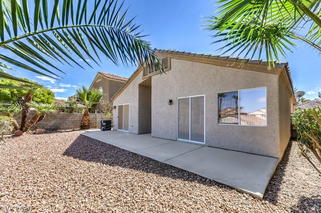 3186 CASTLE CANYON Avenue, Henderson, NV 89052 A spacious concrete patio lines the back of this stucco home surrounded by low-maintenance desert landscaping.