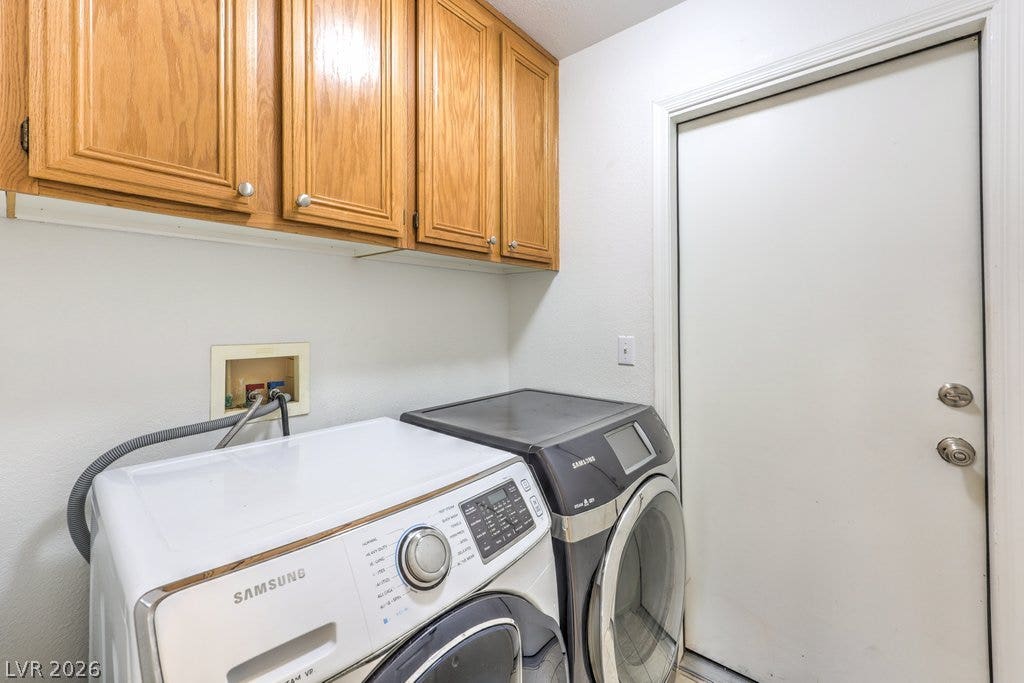 3186 CASTLE CANYON Avenue, Henderson, NV 89052 Oak cabinetry provides overhead storage space in this dedicated laundry area.