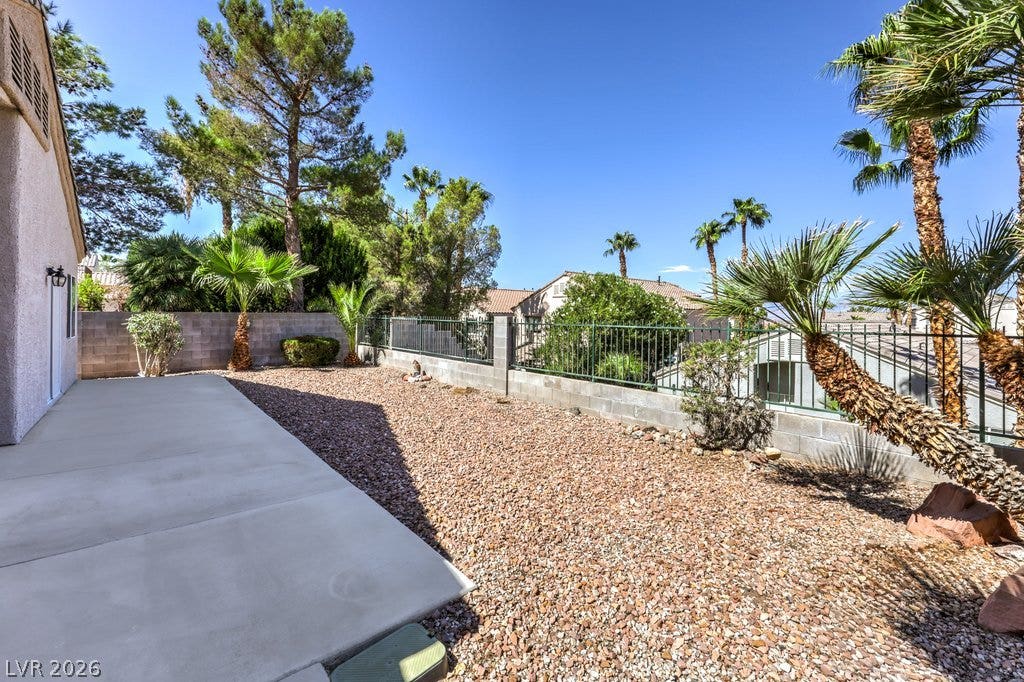 3186 CASTLE CANYON Avenue, Henderson, NV 89052 A spacious concrete patio overlooks a low-maintenance gravel yard bordered by security fencing.