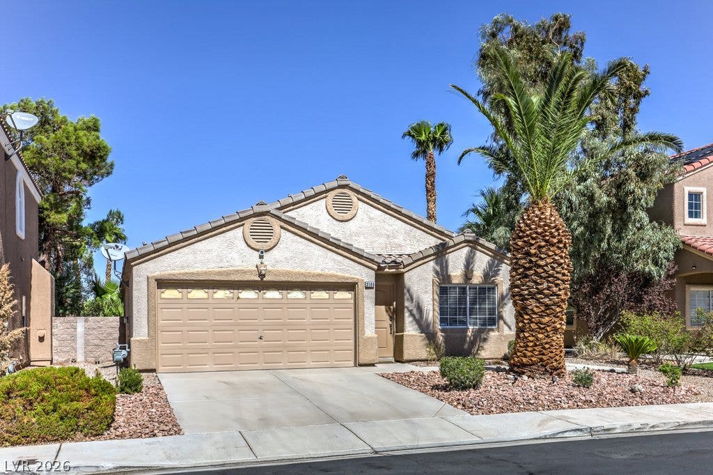 3186 CASTLE CANYON Avenue, Henderson, NV 89052 A classic stucco exterior features a tile roof and clean concrete driveway.