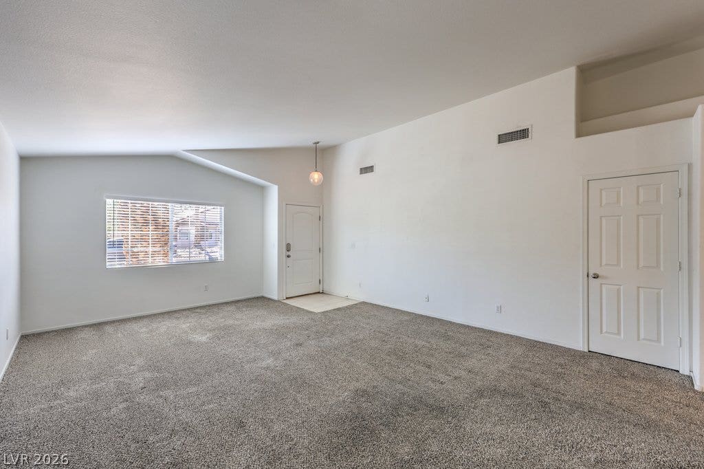 3186 CASTLE CANYON Avenue, Henderson, NV 89052 Vaulted ceilings and plush carpeting define this airy living space near the front entrance.