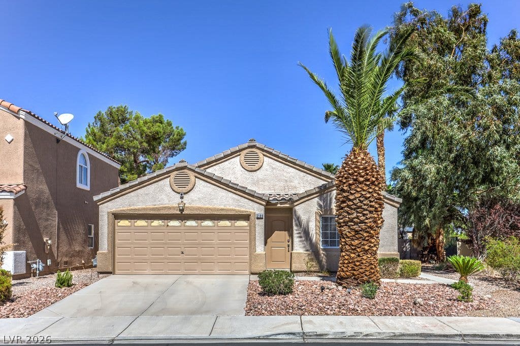 3186 CASTLE CANYON Avenue, Henderson, NV 89052 Desert landscaping and a paved driveway complement this classic stucco exterior.
