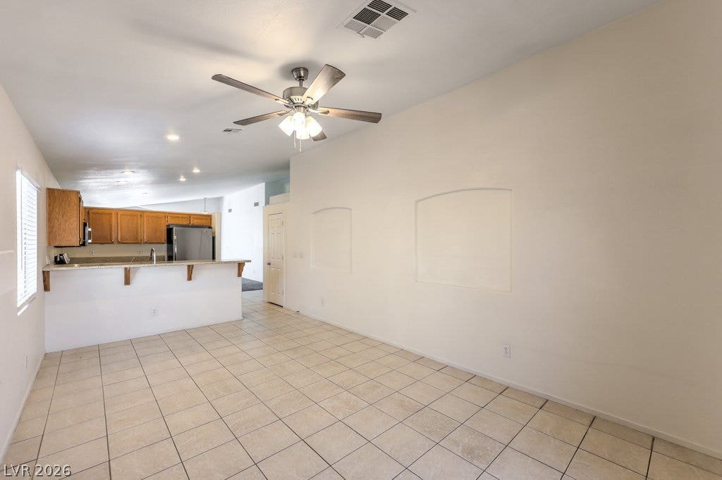 3186 CASTLE CANYON Avenue, Henderson, NV 89052 Tiled flooring and high ceilings connect the open living areas to the kitchen.