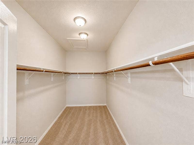 4020 Thomas Patrick Avenue, North Las Vegas, NV 89032 A spacious walk-in closet includes built-in shelving, hanging rods, and carpet flooring.