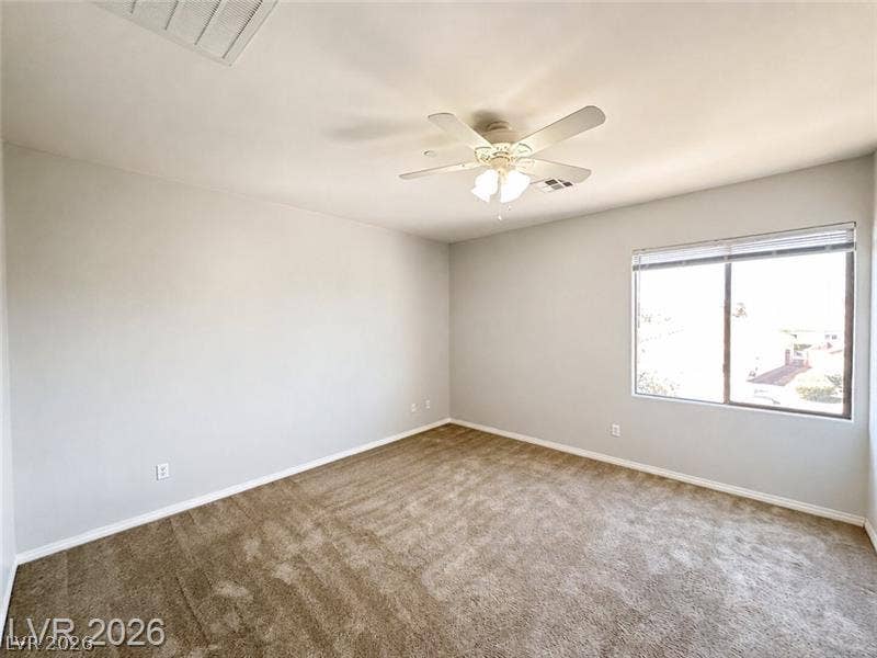 4020 Thomas Patrick Avenue, North Las Vegas, NV 89032 Soft carpeting pairs with a wide window overlooking the neighborhood in this bedroom.