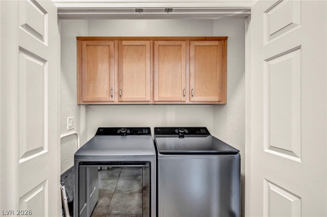 Double doors open to reveal an efficient utility space with built-in cabinetry and tile flooring.