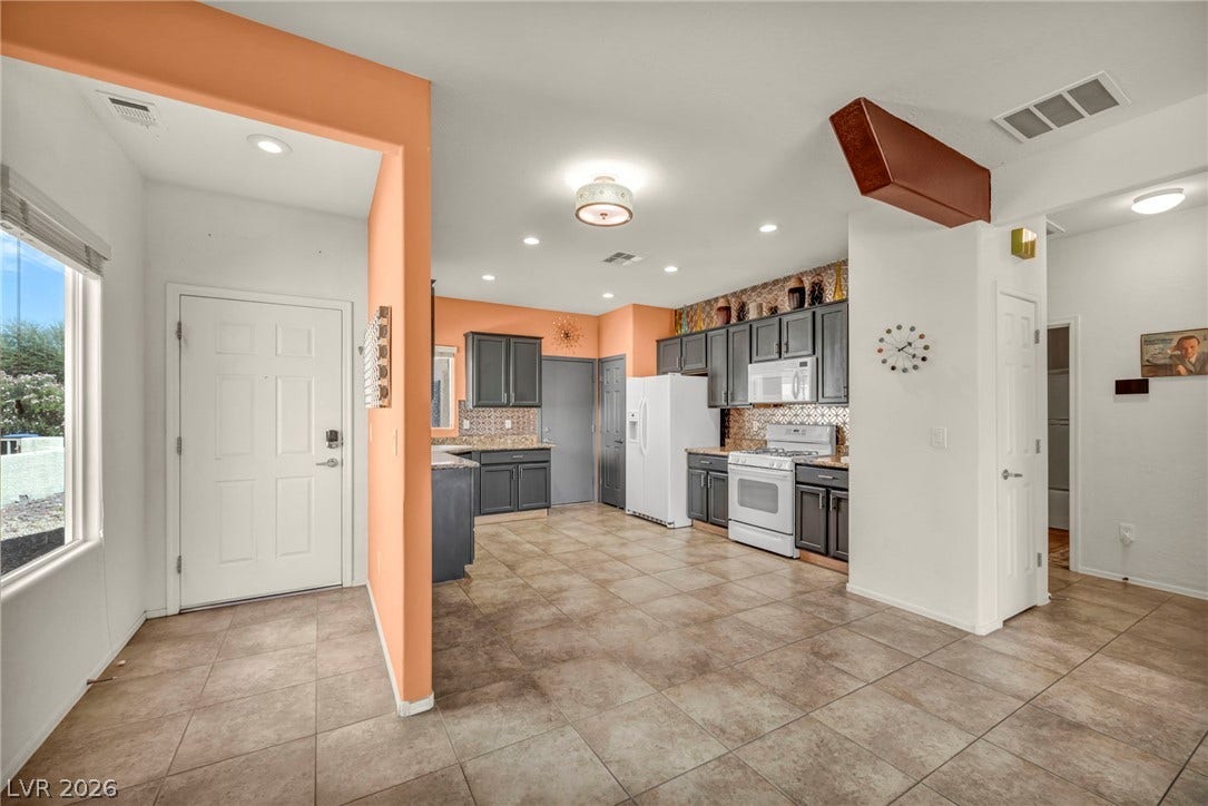 Tile flooring spans from the light-filled entrance foyer directly into the open-concept kitchen.