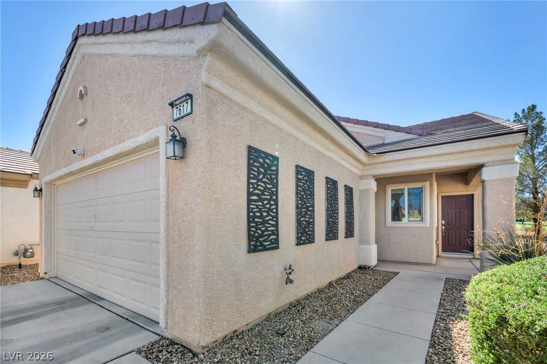 Stucco exterior and tile roofing showcase classic southwest style along the paved entryway.