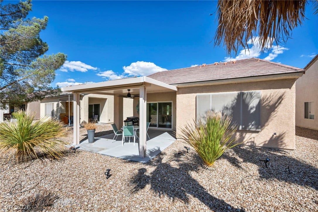 A covered patio overlooks the low-maintenance desert landscaping and gravel yard.