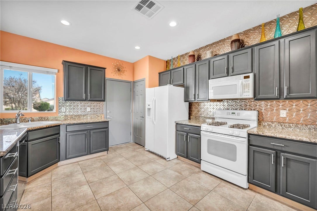 Gleaming tile floors and patterned metallic backsplashes highlight this spacious kitchen layout.