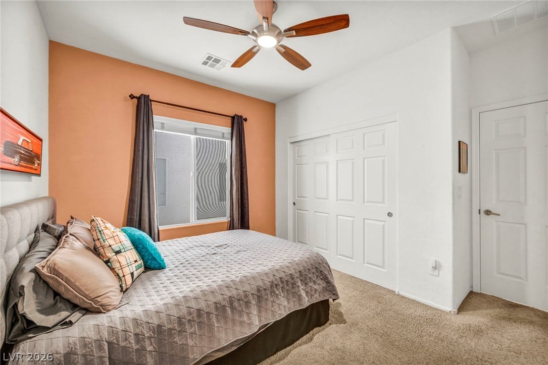 Plush carpeting and abundant natural light create a welcoming atmosphere in this comfortable bedroom.