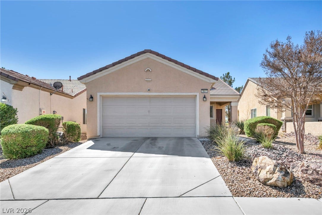 Clean lines and a spacious driveway define this modern single-story residence with a tile roof.