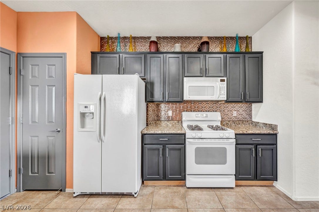 Dark cabinetry and patterned tile details create a modern look in this kitchen.