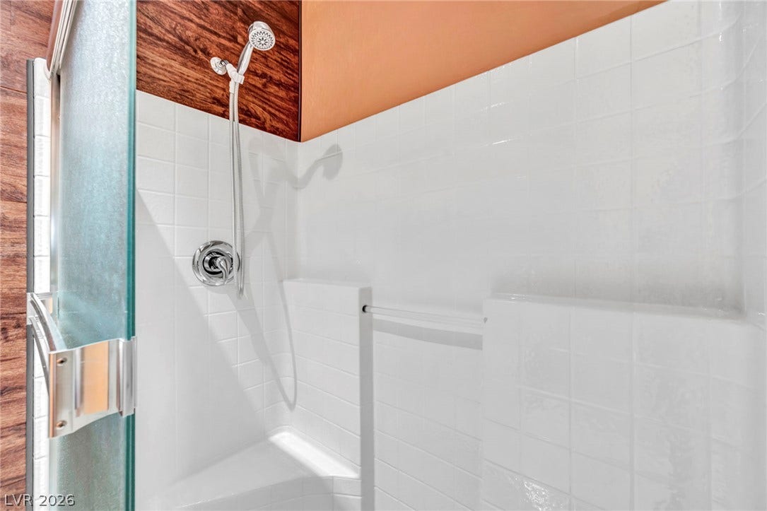 Tiled shower walls and glass doors define this clean and practical bathroom space.