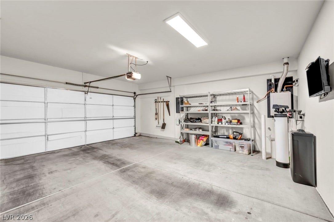 An organized garage space with durable concrete flooring and high ceilings.