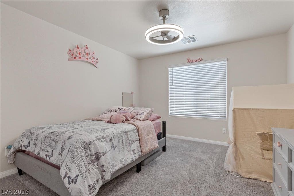 Well-lit sleeping quarters with plush carpeting and a modern ceiling fixture.
