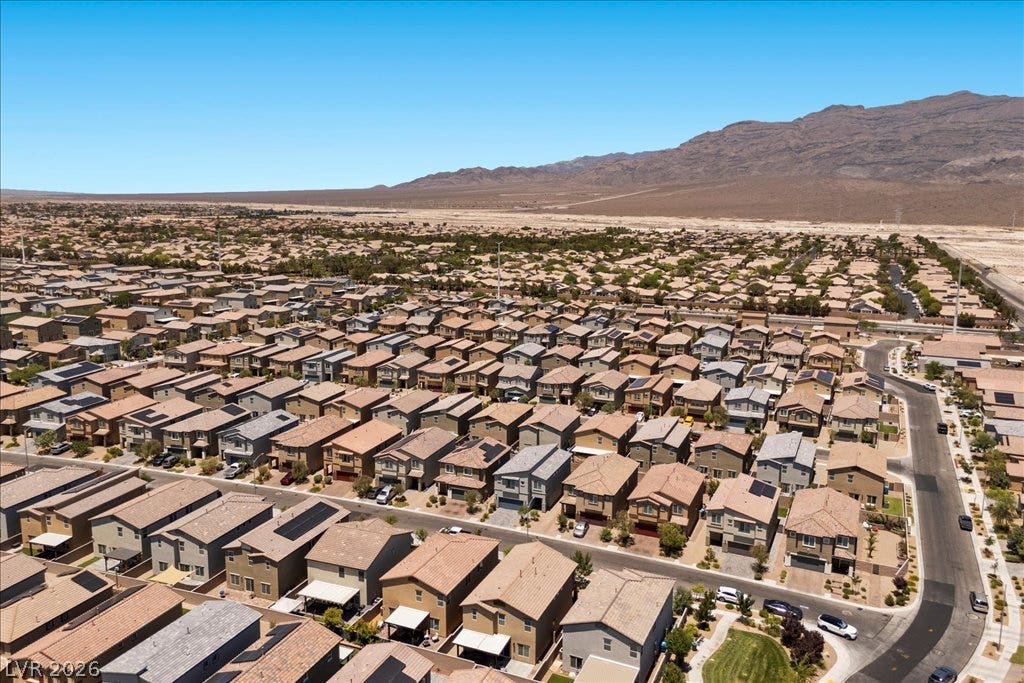 An aerial perspective reveals a vast desert community nestled against a rugged mountain range.