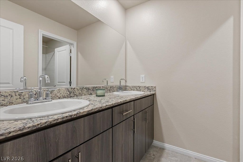 Double vanity with elegant granite counters and undermount sinks offers modern convenience.