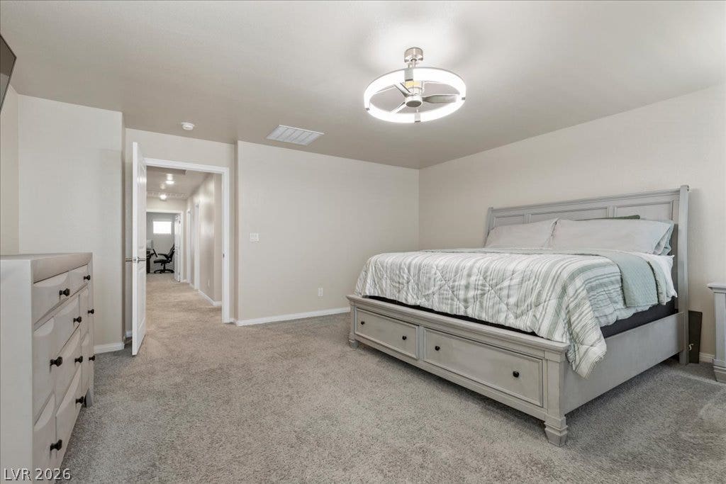 Plush carpet and a contemporary ceiling fixture adorn this tranquil sleeping area.