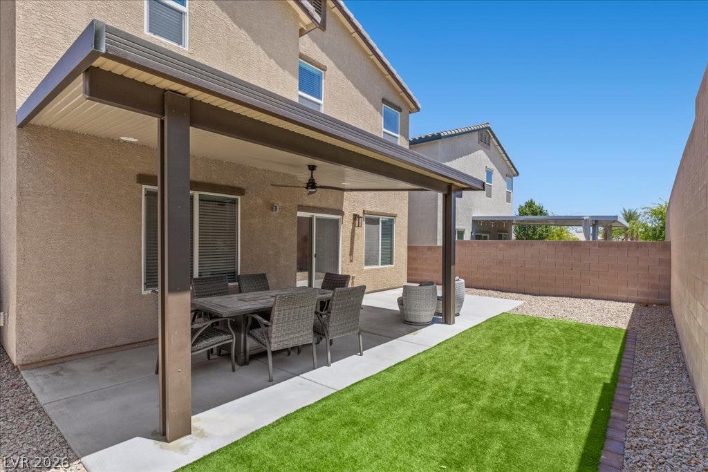 A well-appointed patio with artificial turf offers a pleasant outdoor retreat.